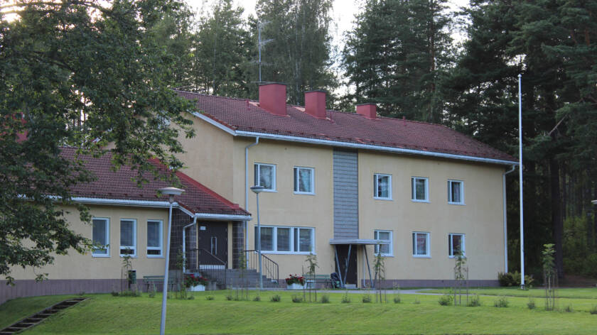Keltainen rapattu kaksikerroksinen vanhahko talo.
