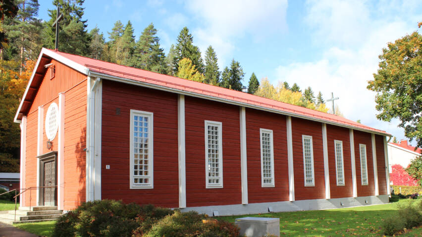 Punainen hirrestä tehty kirkko, jossa valkoiset ikkunapielet ja laudoitukset.