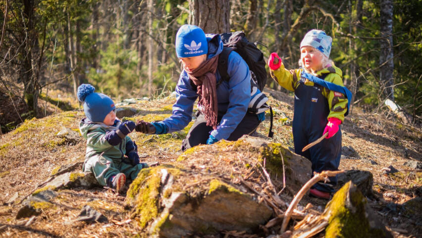 Nainen kahden lapsen kanssa metsässä