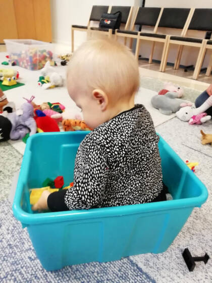 Vauva leikkii lelulaatikossa