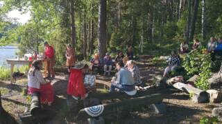 ihmisiä koolla luonnossa nuotion äärellä