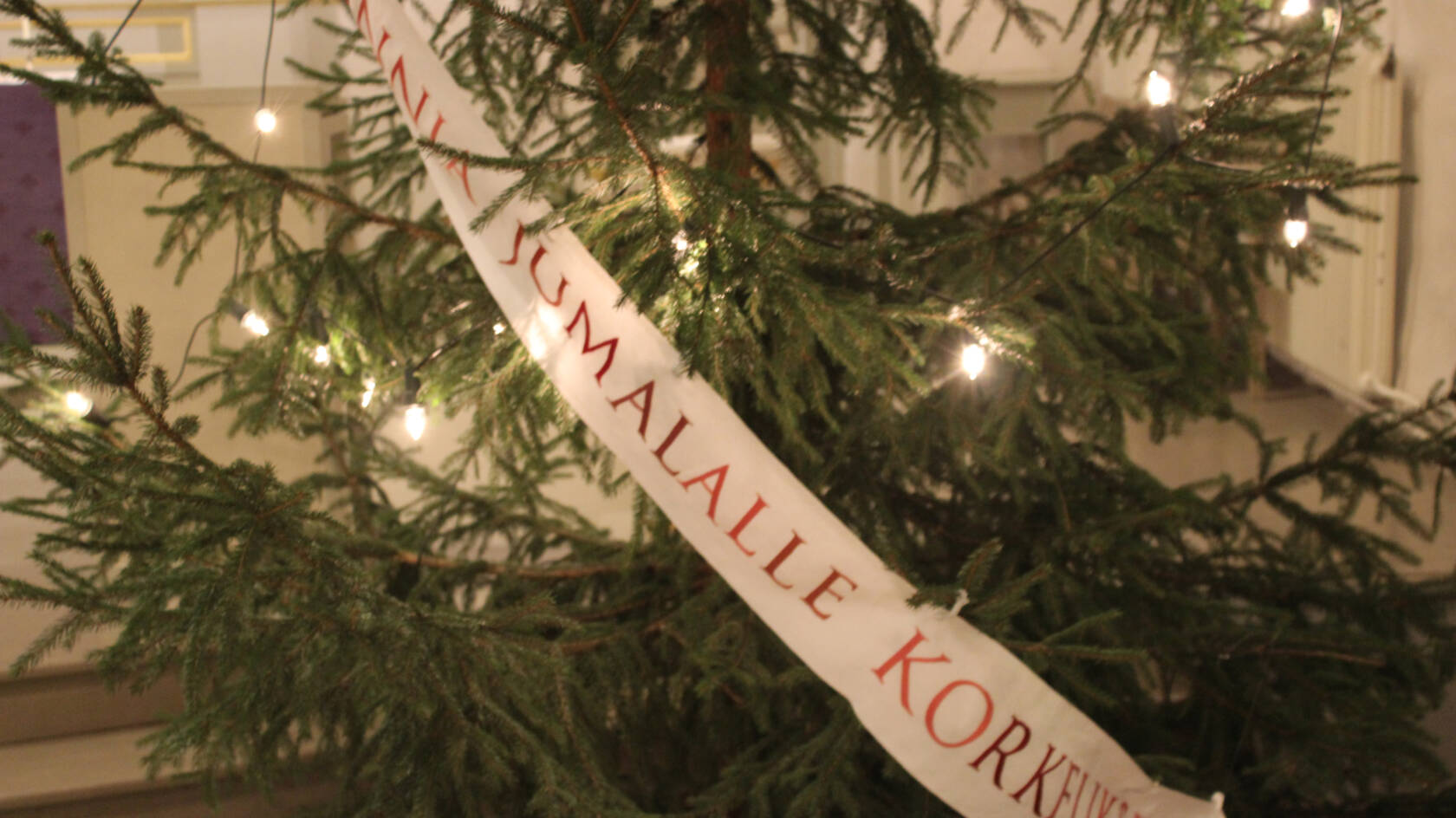 Joulukuusi Pyhän Laurin kirkossa. Kuusessa nauha, jossa lukee Kunnia Jumalalle korkeuksissa.